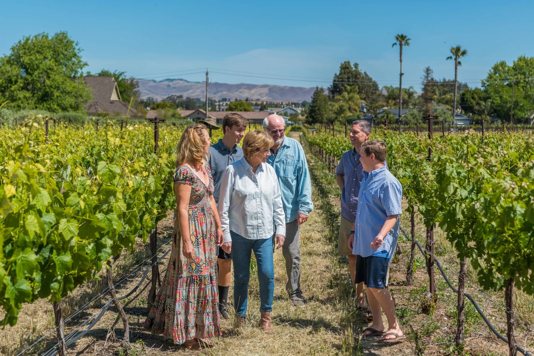 Winery owners Garry and Nancy Rodrigue with their extended family are walking through the vineyards on the RM estate