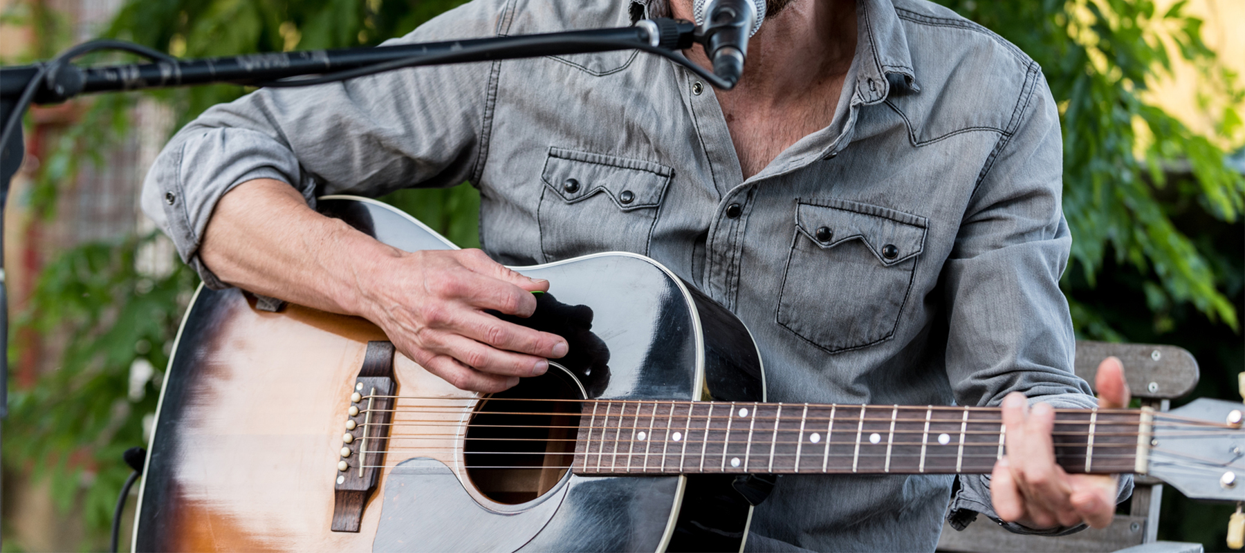 Close up of someone playing an acoustic guitar during a Rodrigue Molyneaux winery event.