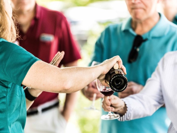 wine being poured for tasting by wine club members